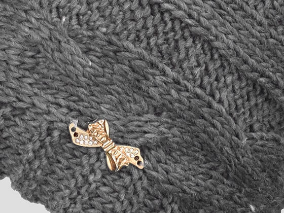 Dettaglio - berretto donna - cappello morbido tricot a trecce con pom-pon decorato da un fiocco d'oro con strass