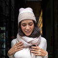 Cappello e sciarpa ad anello pelosi colori tenui modella