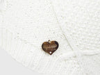 Dettaglio cuoricino - cappello lavorato a trecce con catene con lurex e medaglietta